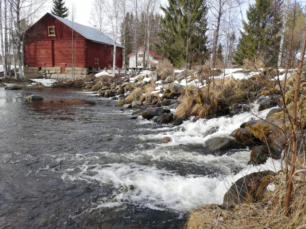 Koski alapuolelta ja toisella puolella näkyy myllyn takaosa.